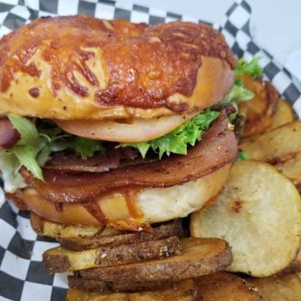 A Big Mic's Saloon & BBQ Smokehouse sandwich with bacon, lettuce, tomato, and a side of fries.