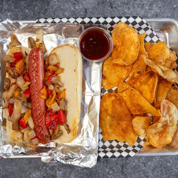 Big Mic's Saloon & BBQ Smokehouse hot dog with grilled onions, peppers, mushrooms, and chips.