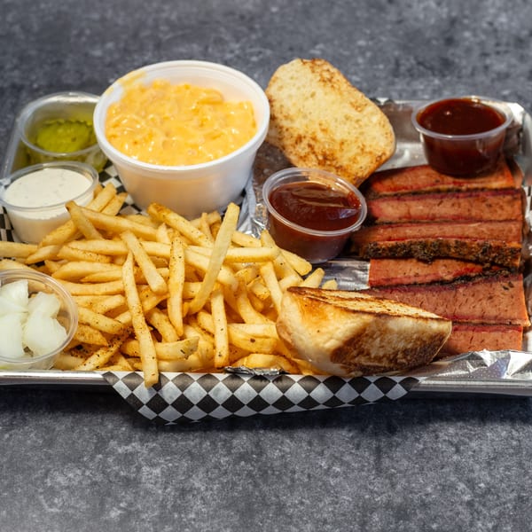 Big Mic's BBQ brisket platter with fries, mac and cheese, toast, and various sauces.